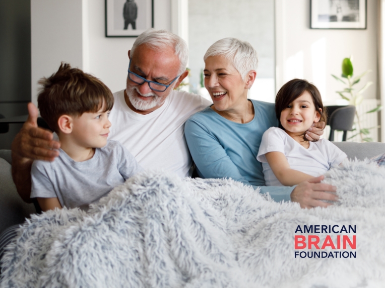 Family on couch under blanket.
